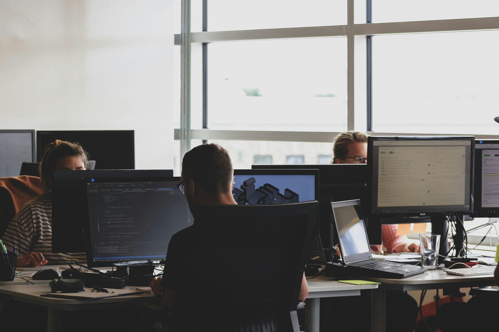 An open-plan office, staff working at desktop workstations